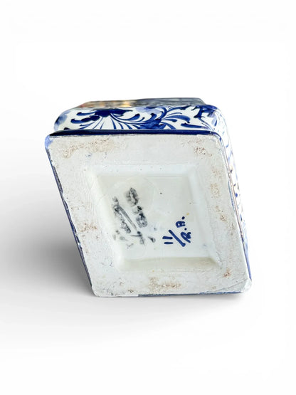 Underside of a blue and white porcelain vase with decorative floral pattern and maker's marks
