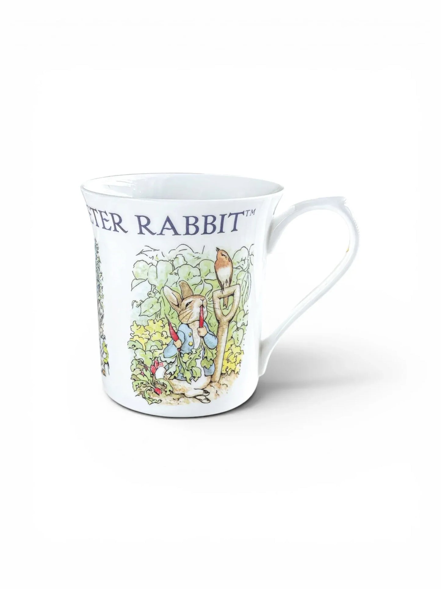 Beatrix Potter Peter Rabbit centenary mug featuring Peter in Mr. McGregor’s garden with a robin on a spade.