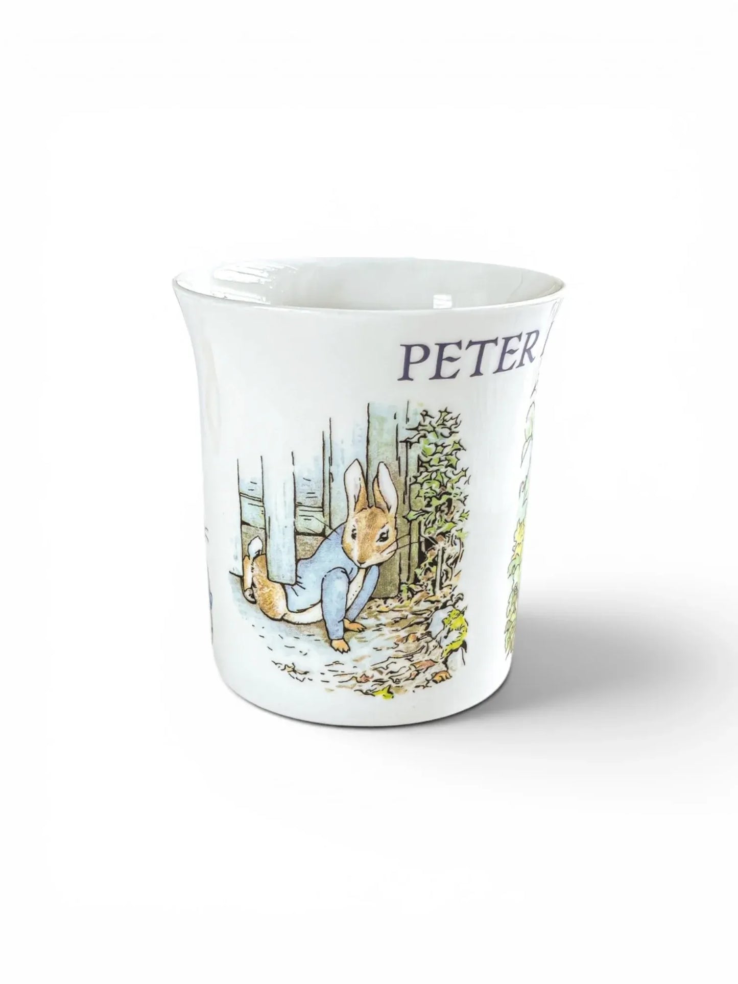Close-up of Peter Rabbit escaping under a garden gate on a Queen’s Fine Bone China commemorative mug.