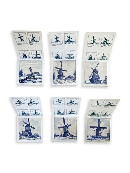 A complete set of six Regina Delft ceramic tiles, each featuring a different traditional Dutch windmill illustration, displayed inside their original white cardboard collector sleeves.