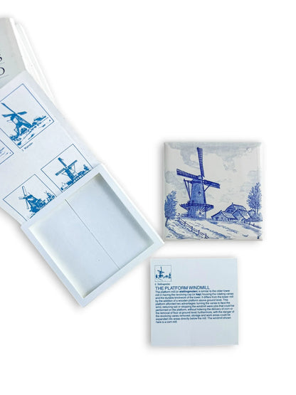 Close-up of a Regina Delft Blue tile depicting a Dutch windmill alongside its original educational slip titled "The Platform Windmill," detailing the history and function of the mill.