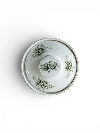 Top-down view of the Grön Anna sugar bowl lid, showing fine crazing and the central green floral motif.