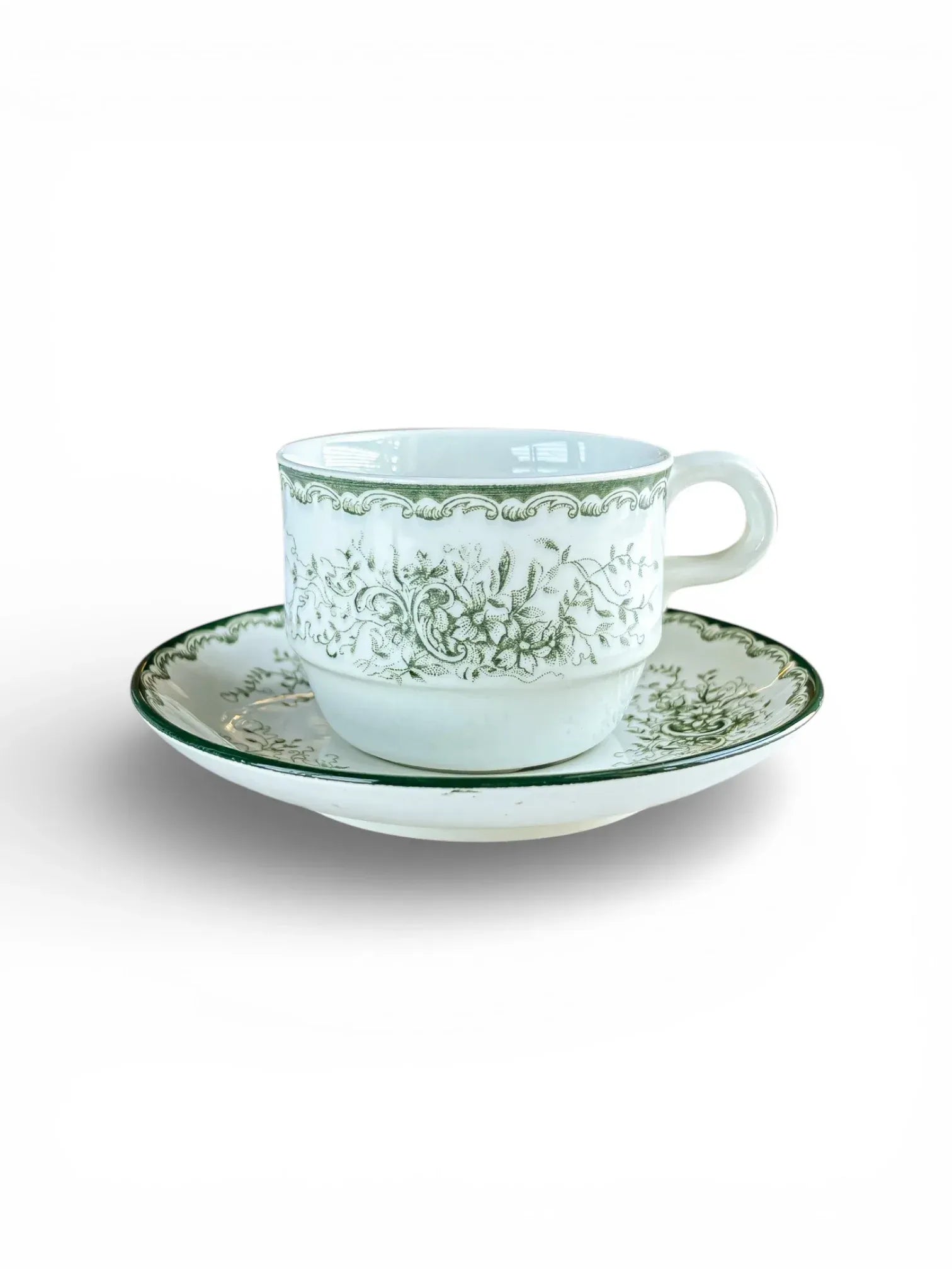 A side-view studio shot of a Rörstrand Grön Anna stackable coffee cup and matching saucer, featuring the signature green floral pattern and a recessed base for easy stacking.