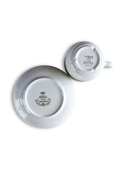 The undersides of the Grön Anna cup and saucer, clearly showing the green "Rörstrand Sweden" backstamps and the VDN F555 quality certification code.