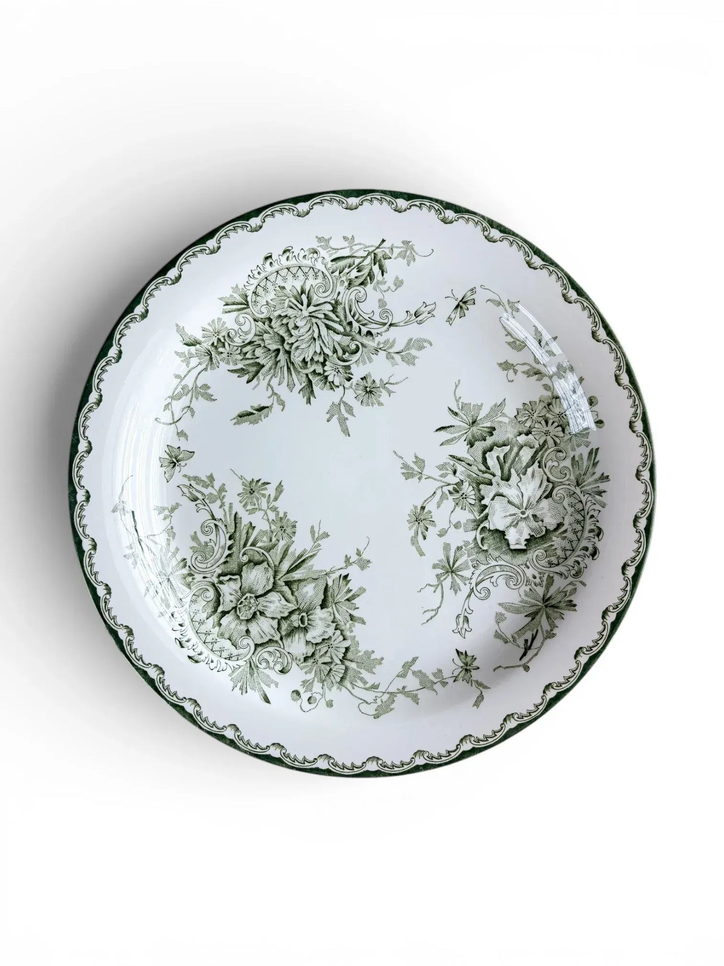 Top-down view of a Rörstrand Grön Anna dinner plate, featuring a deep green Neo-Rococo floral pattern and scalloped rim on a white flintware base.