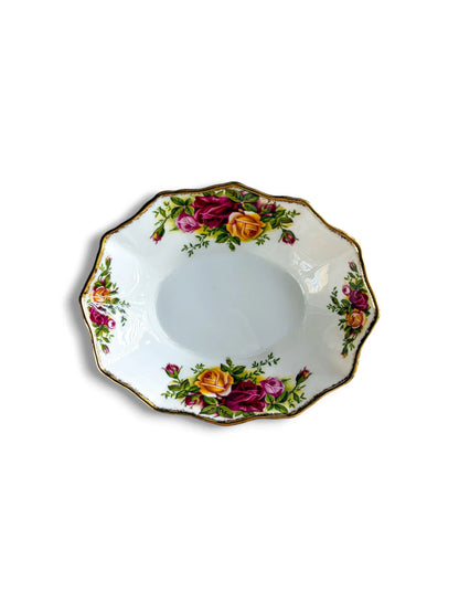 A top-down view of an oval Royal Albert Old Country Roses bonbon dish on a white background. The fine bone china dish features vibrant clusters of pink, yellow, and deep red roses with a scalloped, gold-trimmed edge.