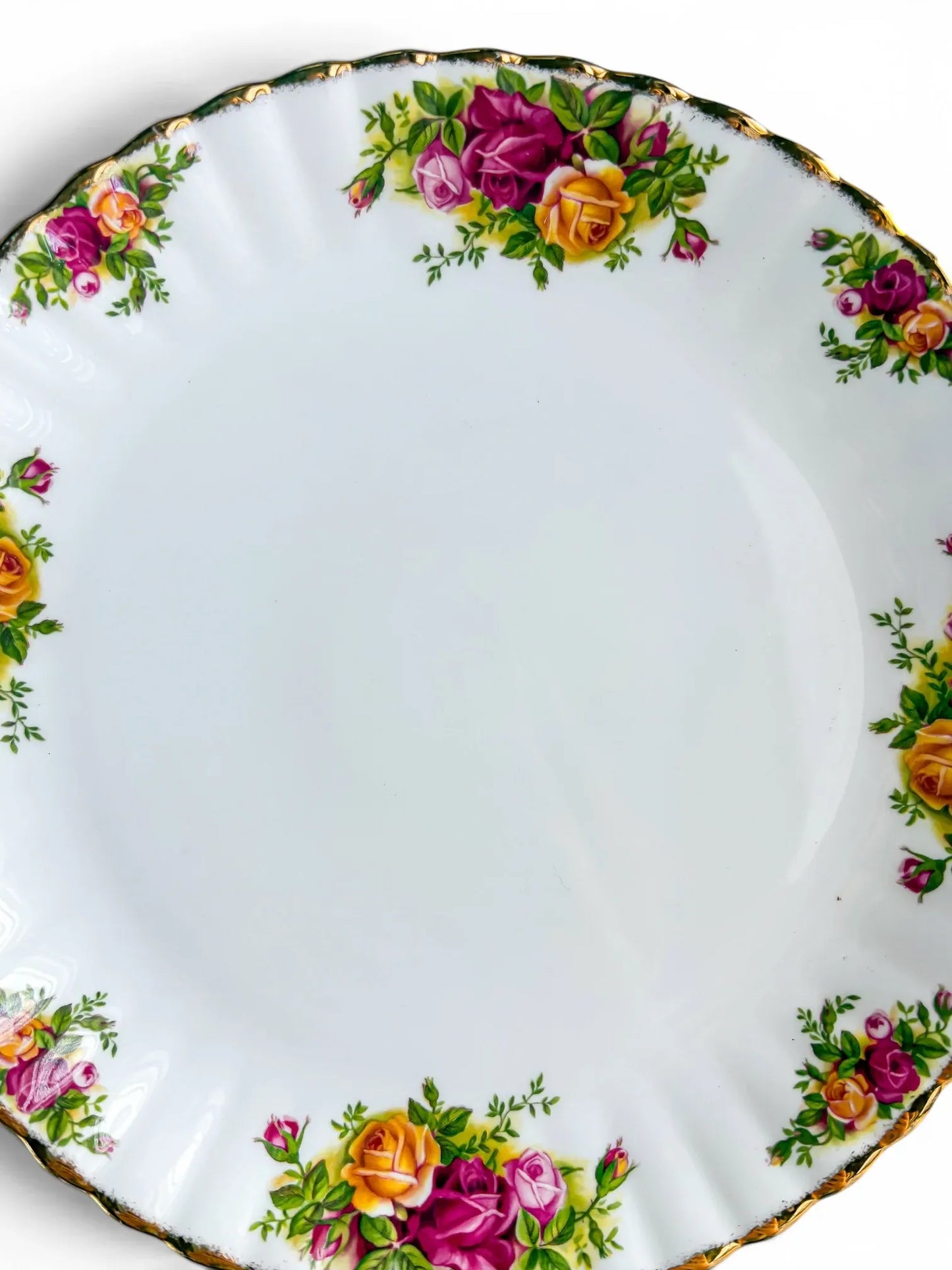 Close-up detail of the vibrant pink, red, and yellow rose transfers and intact 22-carat gold stippling on the scalloped rim of the Royal Albert Old Country Roses cake plate.