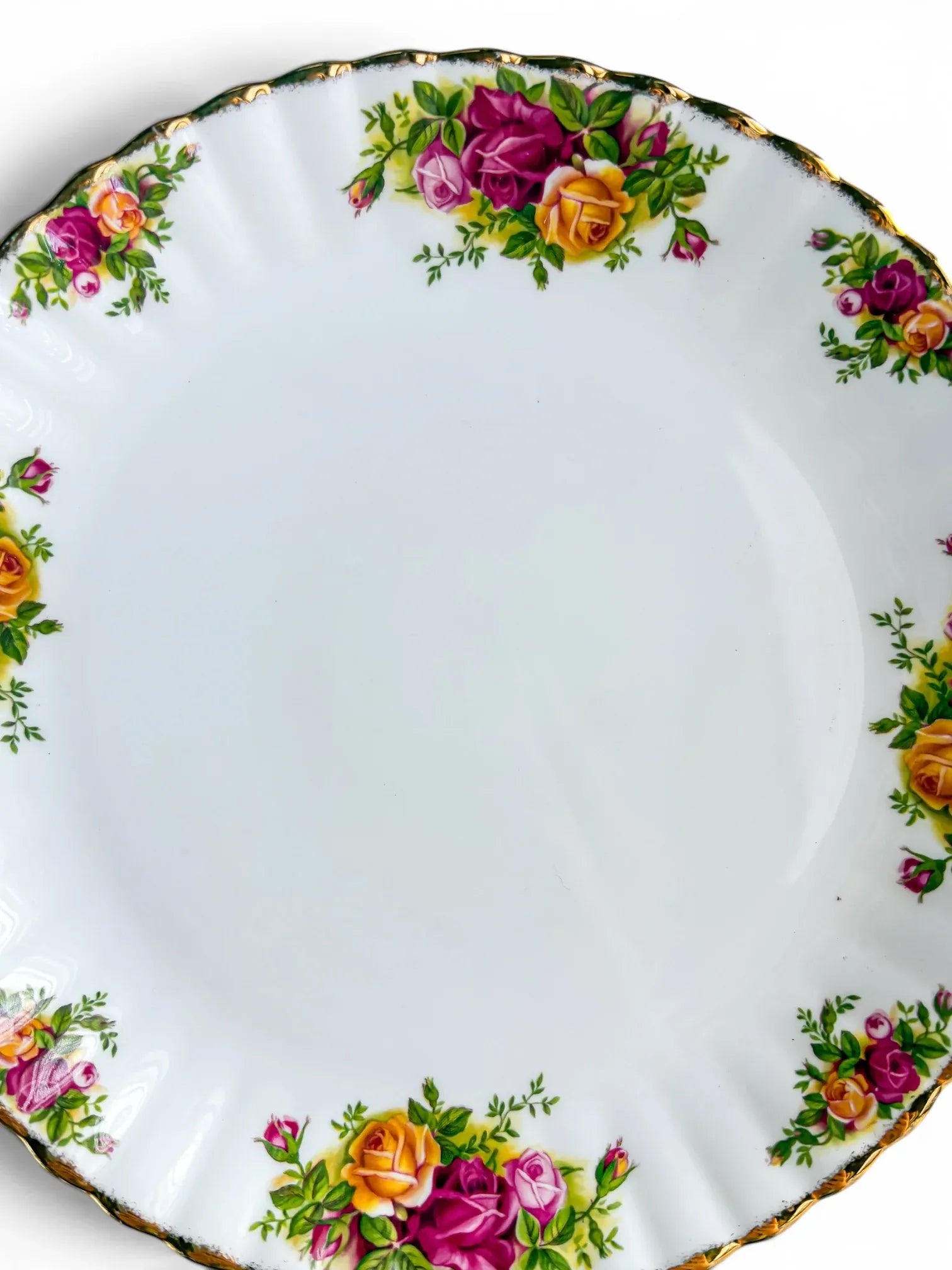 Close-up detail of the vibrant pink, red, and yellow rose transfers and intact 22-carat gold stippling on the scalloped rim of the Royal Albert Old Country Roses cake plate.