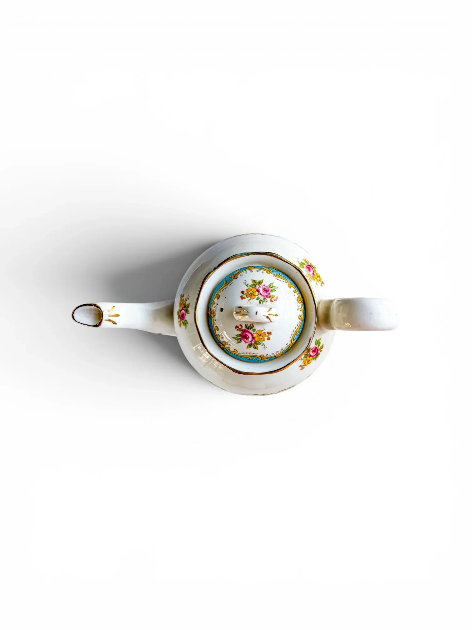 Overhead view of the coffee pot with its lid securely in place, highlighting the circular turquoise and gold scrolling border along the rim and the delicate floral spray painted on top of the domed lid.