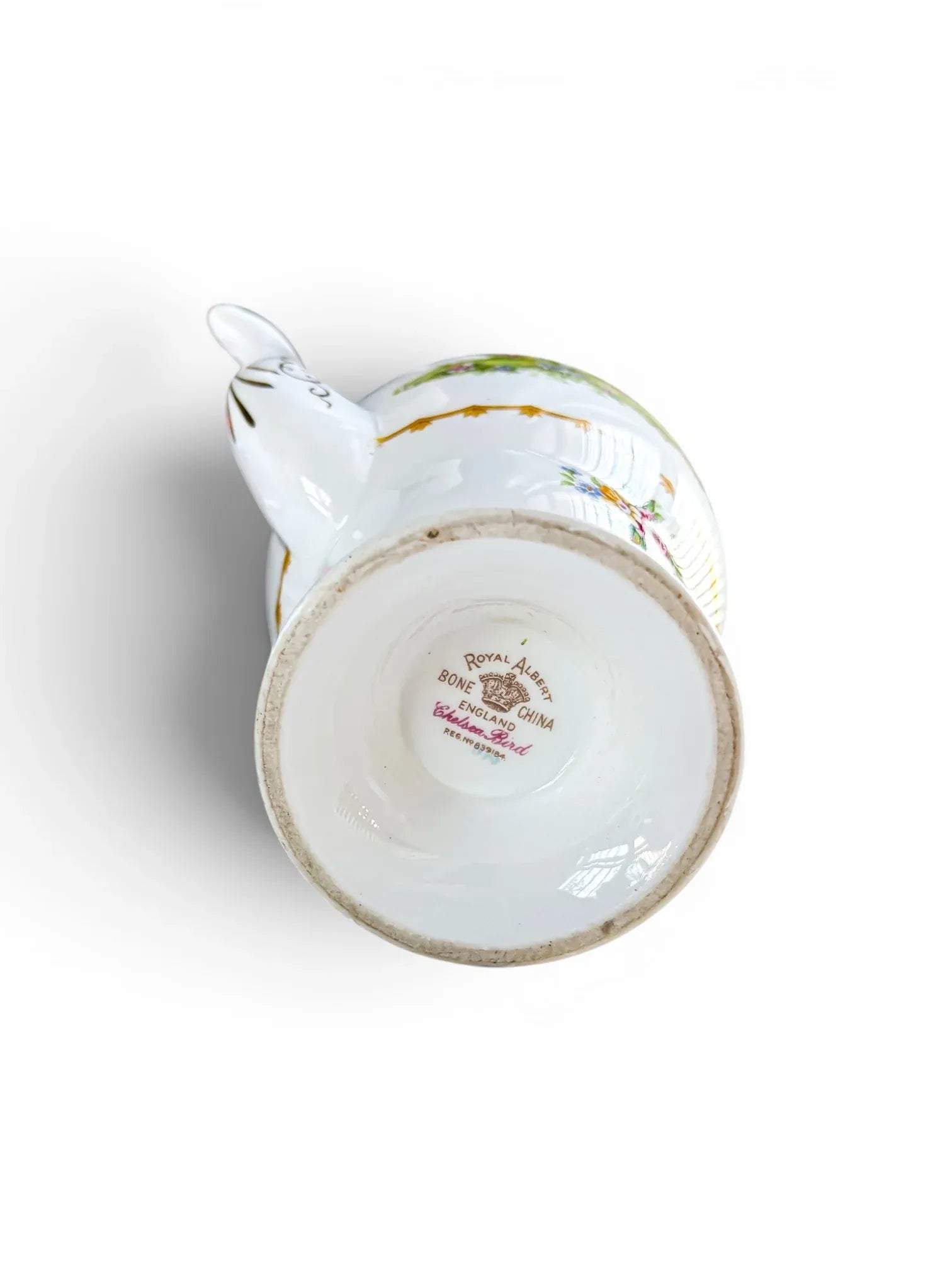Macro view of the underside of the pedestal foot ring, displaying the crisp, authentic brown Royal Albert crown backstamp and the pink script reading "Chelsea Bird" alongside the registration number 839184.