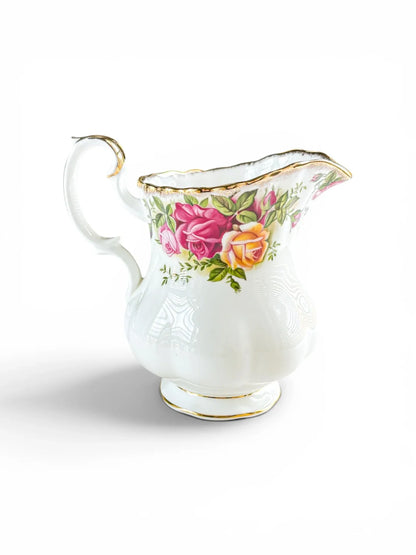 Opposite side profile of the Royal Albert Old Country Roses milk jug, showcasing the full cluster of deep burgundy and peach tea roses with intact 22-carat gold stippling on the scalloped rim.