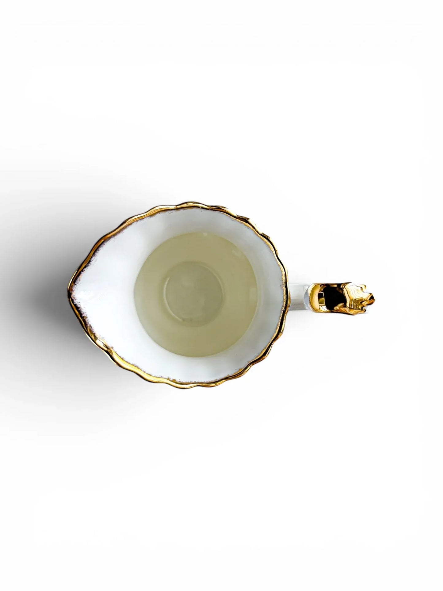 Overhead top-down view looking into the clean, white porcelain interior of the Royal Albert Old Country Roses creamer jug, detailing the texture of the gold sponged rim and pour spout.