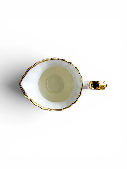 Overhead top-down view looking into the clean, white porcelain interior of the Royal Albert Old Country Roses creamer jug, detailing the texture of the gold sponged rim and pour spout.