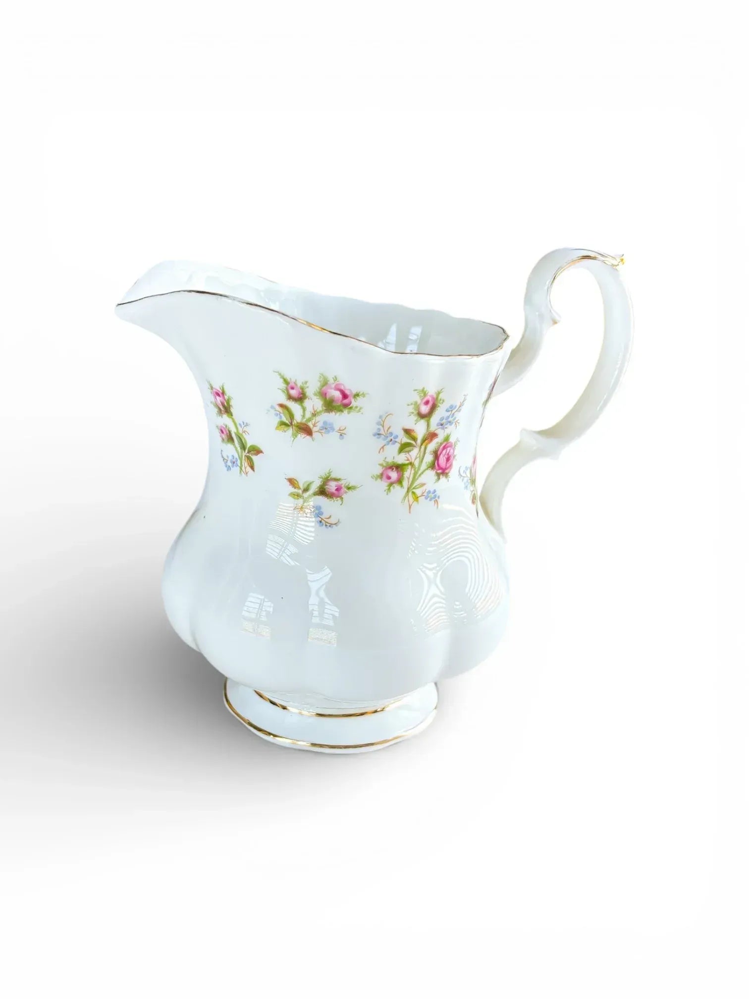 Profile view of a Royal Albert Winsome bone china creamer on the Montrose shape featuring pink rose sprays and a scrolled handle.