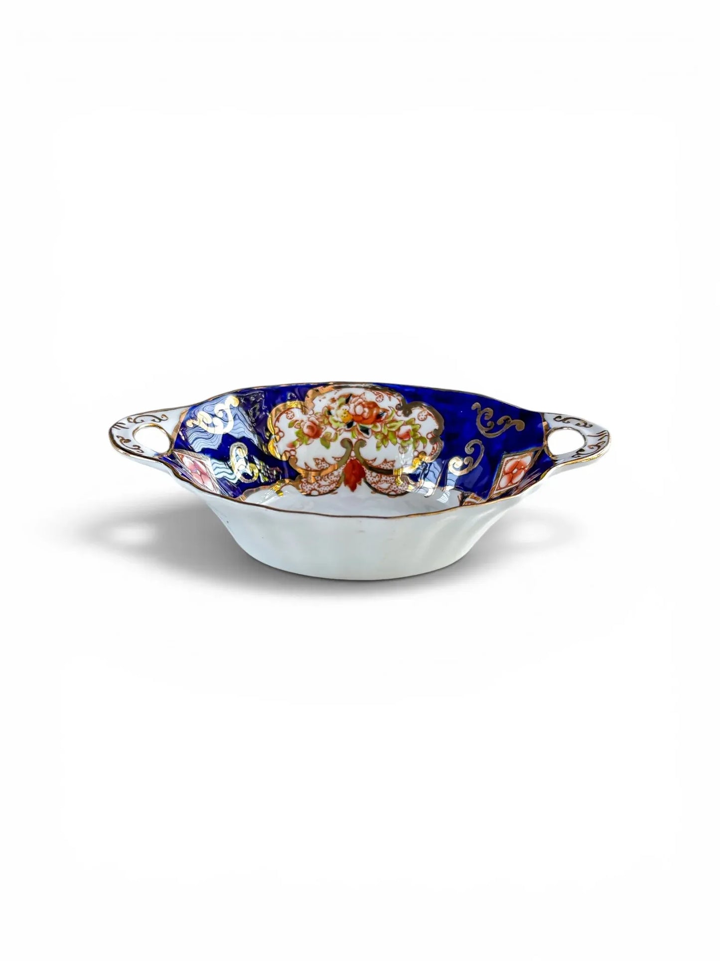 A side perspective of a Royal Albert Derby porcelain sweetmeat dish. The image highlights the scalloped rim, pierced "ear" handles, and the depth of the bowl, showcasing the detailed gold filigree and Imari-style floral patterns.