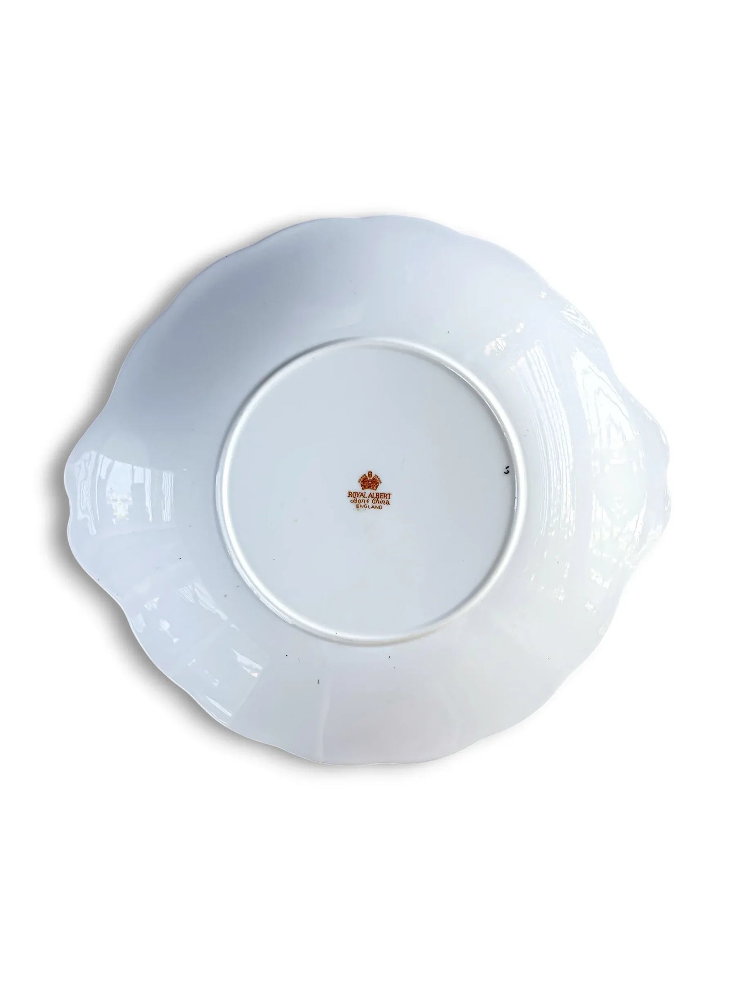 The underside of the Royal Albert Heirloom cake plate, showing the clean white porcelain base and the official orange-toned Royal Albert Bone China England backstamp in the centre.