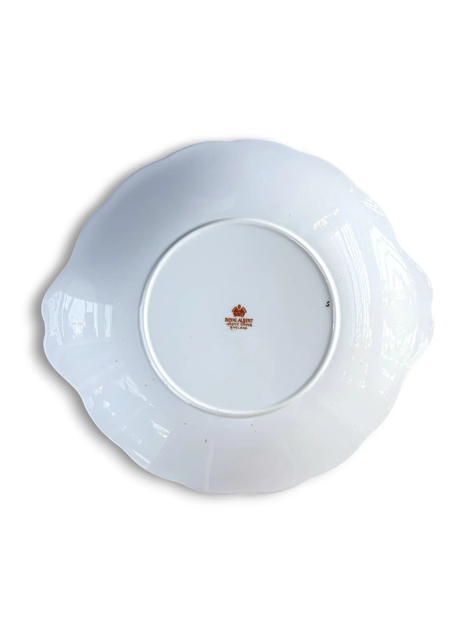 The underside of the Royal Albert Heirloom cake plate, showing the clean white porcelain base and the official orange-toned Royal Albert Bone China England backstamp in the centre.