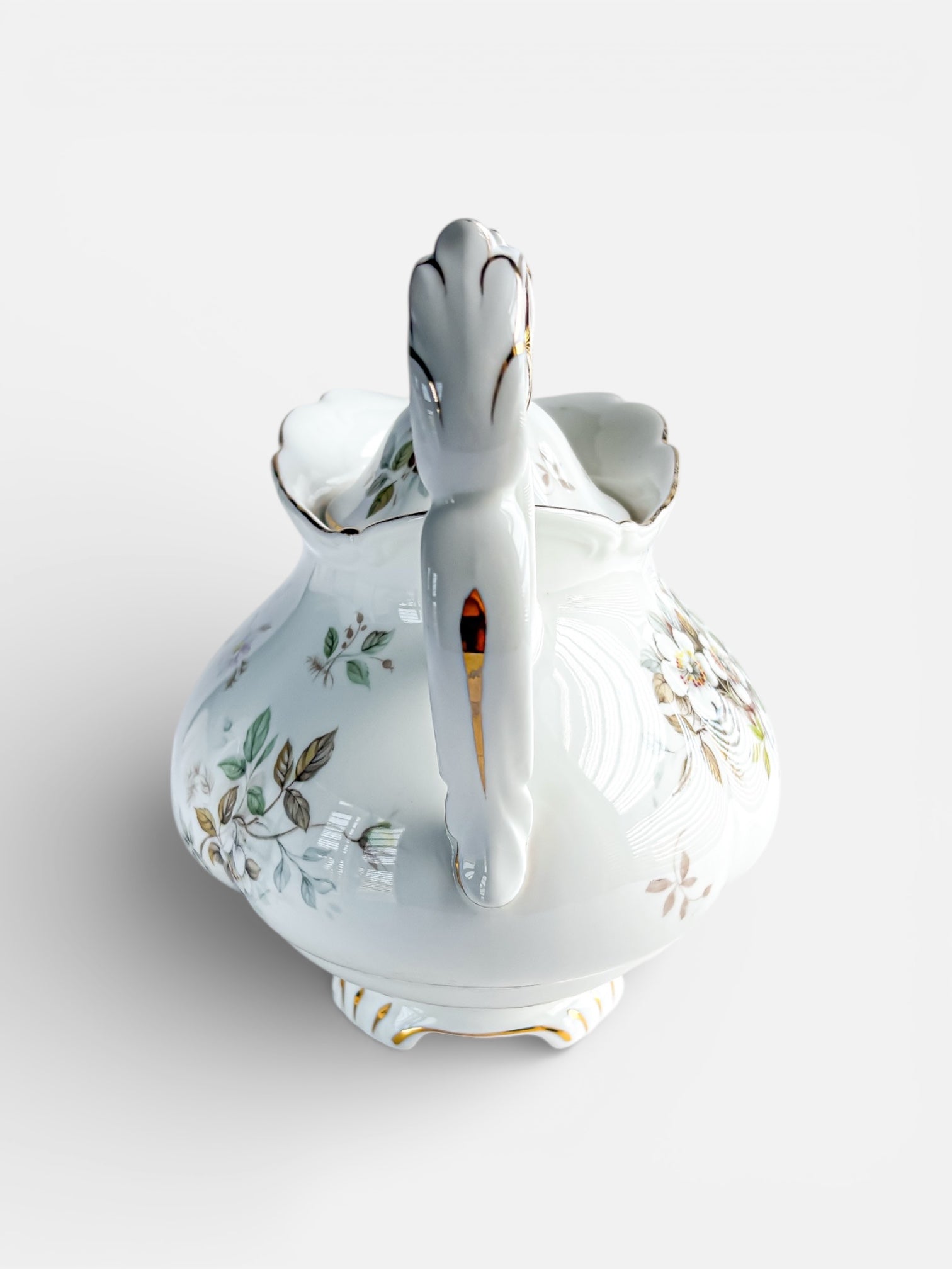 Vintage porcelain tea pot with floral design and gold accents, ornate handle and lid