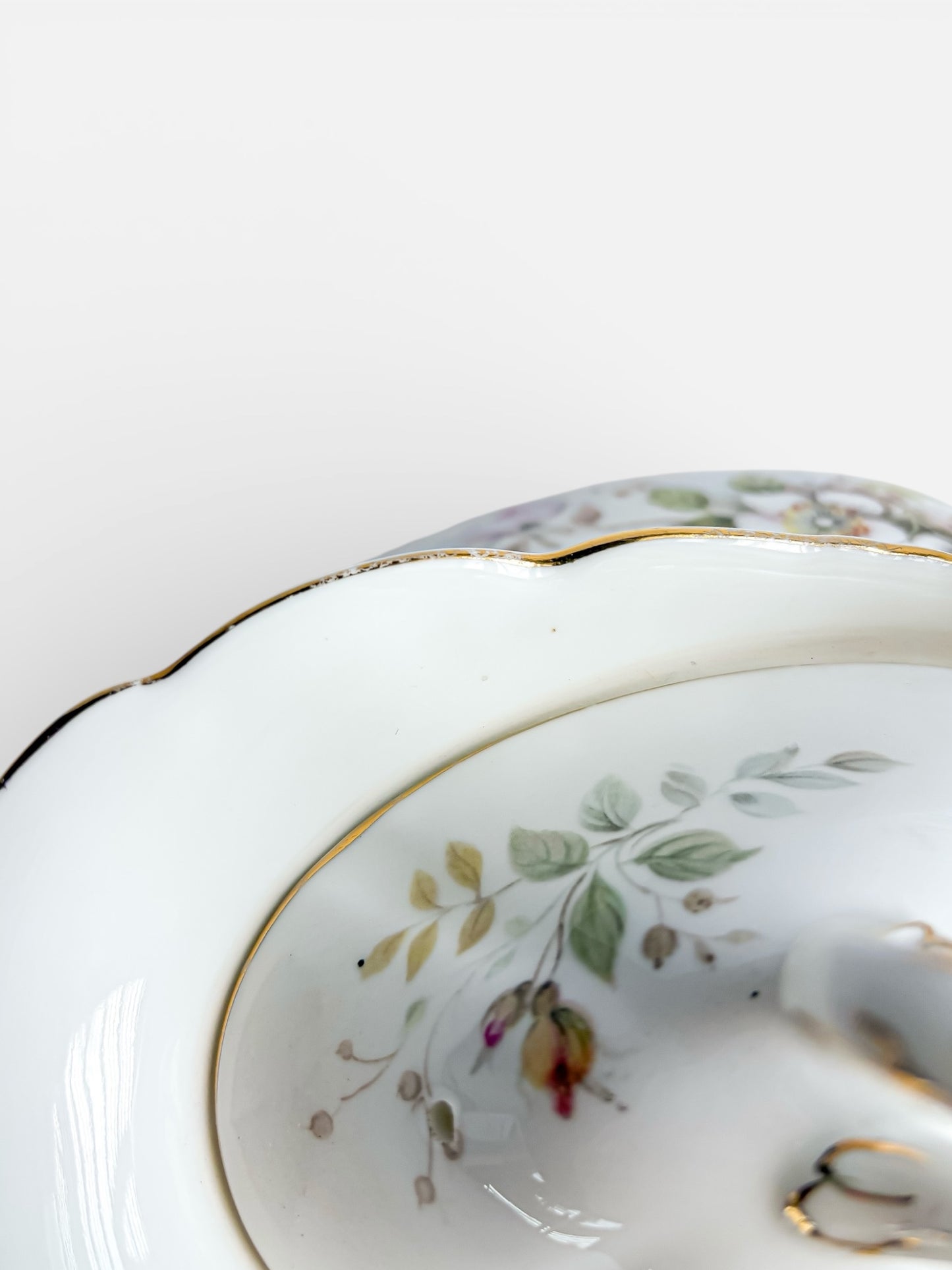 Close-up of vintage porcelain dish with floral design and gold trim