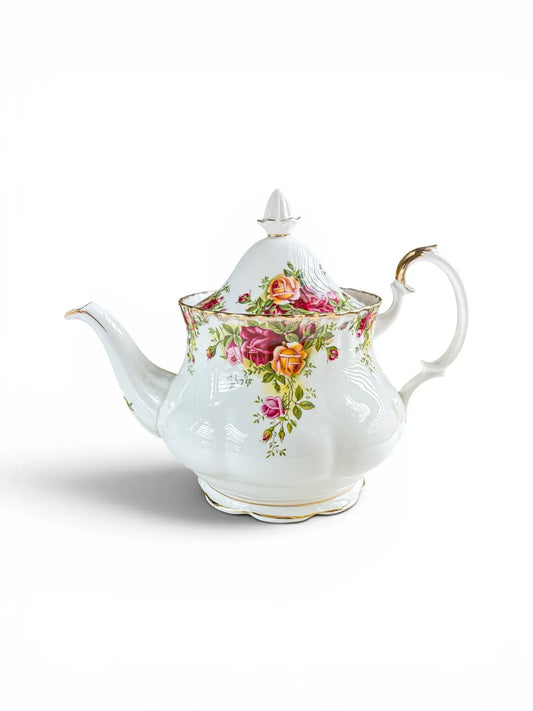 Side profile of a large vintage Royal Albert Old Country Roses 1.25L teapot on a white background, highlighting the curved Montrose body, spout, and high-domed lid with its gilded finial.