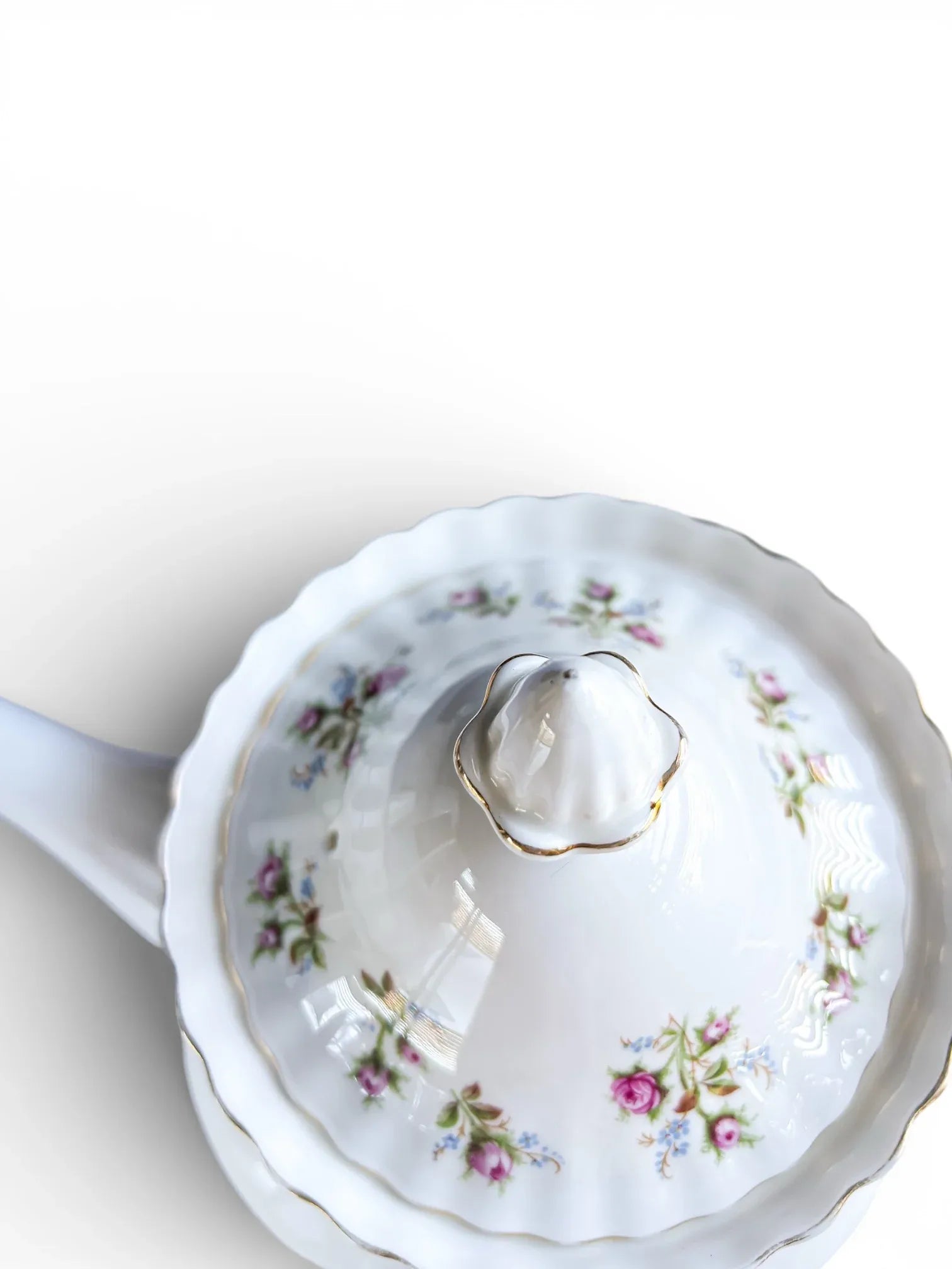 Close-up of the domed teapot lid showing the floral decoration, steam vent, and gold-trimmed finial.
