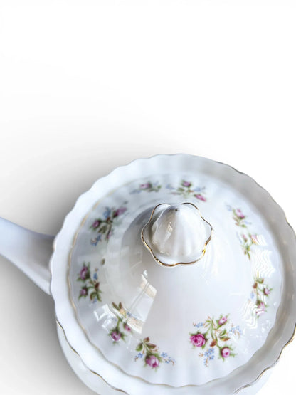 Close-up of the domed teapot lid showing the floral decoration, steam vent, and gold-trimmed finial.