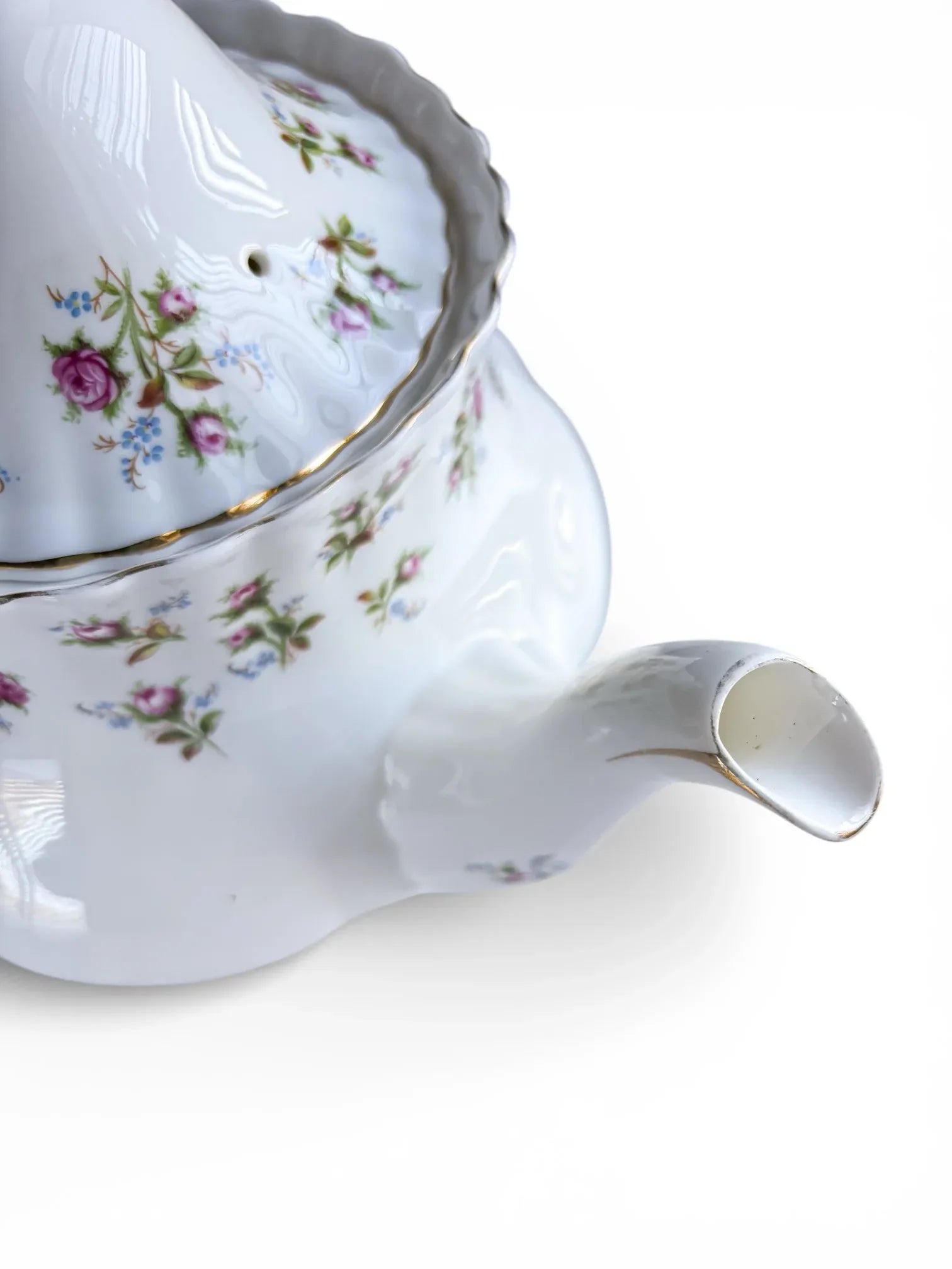 Close-up of the elegant swan-neck spout of the Winsome teapot with gold-lined rim.