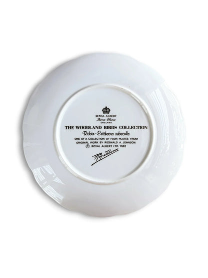 The backstamp of a vintage Royal Albert fine bone china plate showing the black crown logo, "Made in England," and text identifying it as part of "The Woodland Birds Collection" featuring the Robin (Erithacus rubecula), dated 1982 with the artist’s signature.