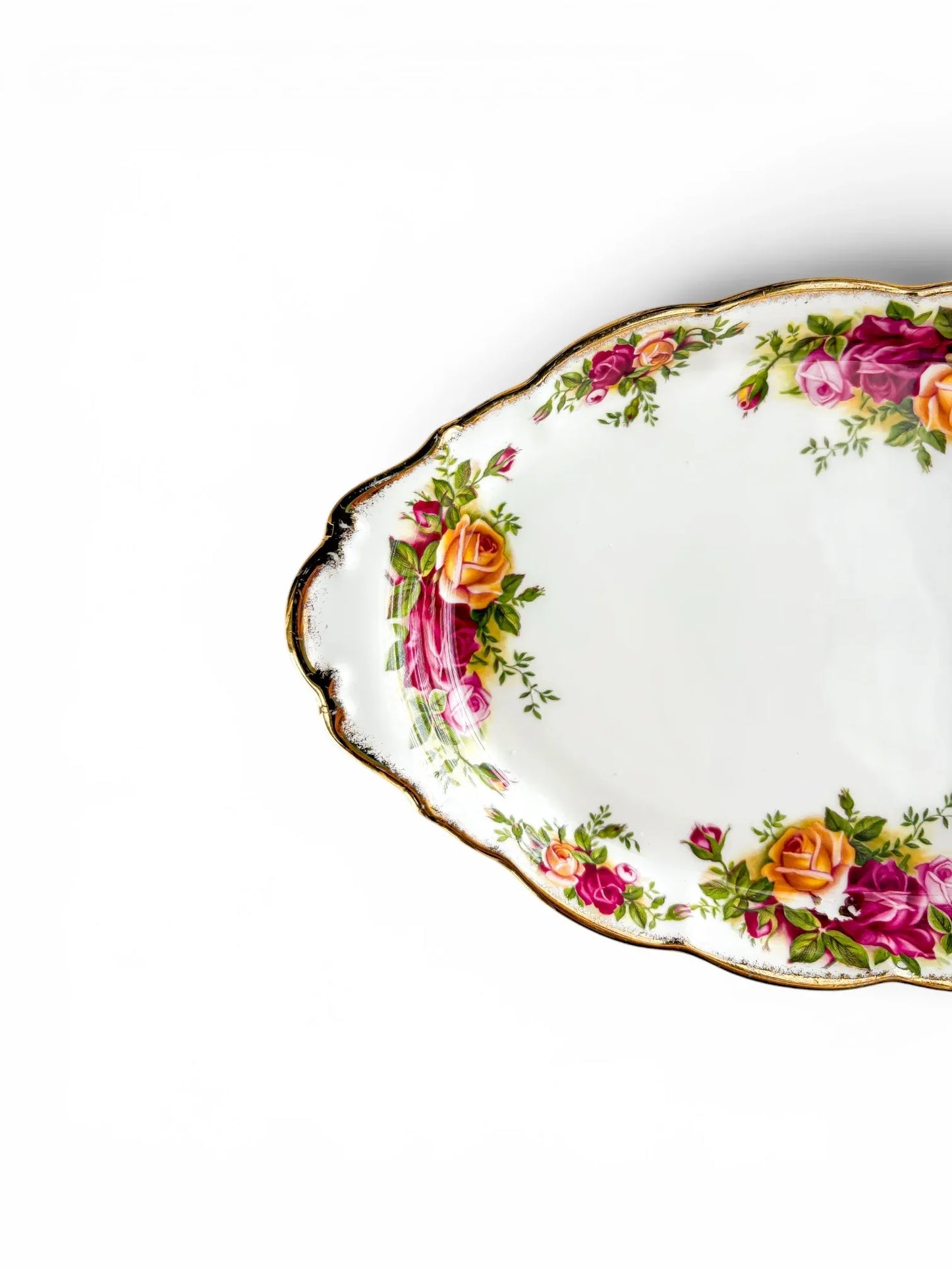Close-up detail of the vibrant pink and yellow rose transfers and thick 22-carat gold stippled rim on the edge of the oval serving tray.