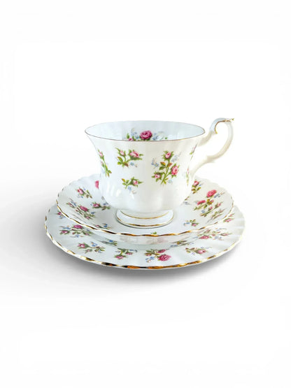 Vintage Royal Albert Winsome bone china trio featuring a teacup, saucer, and side plate with a delicate pink rose and blue forget-me-not pattern on a white fluted Montrose shape.