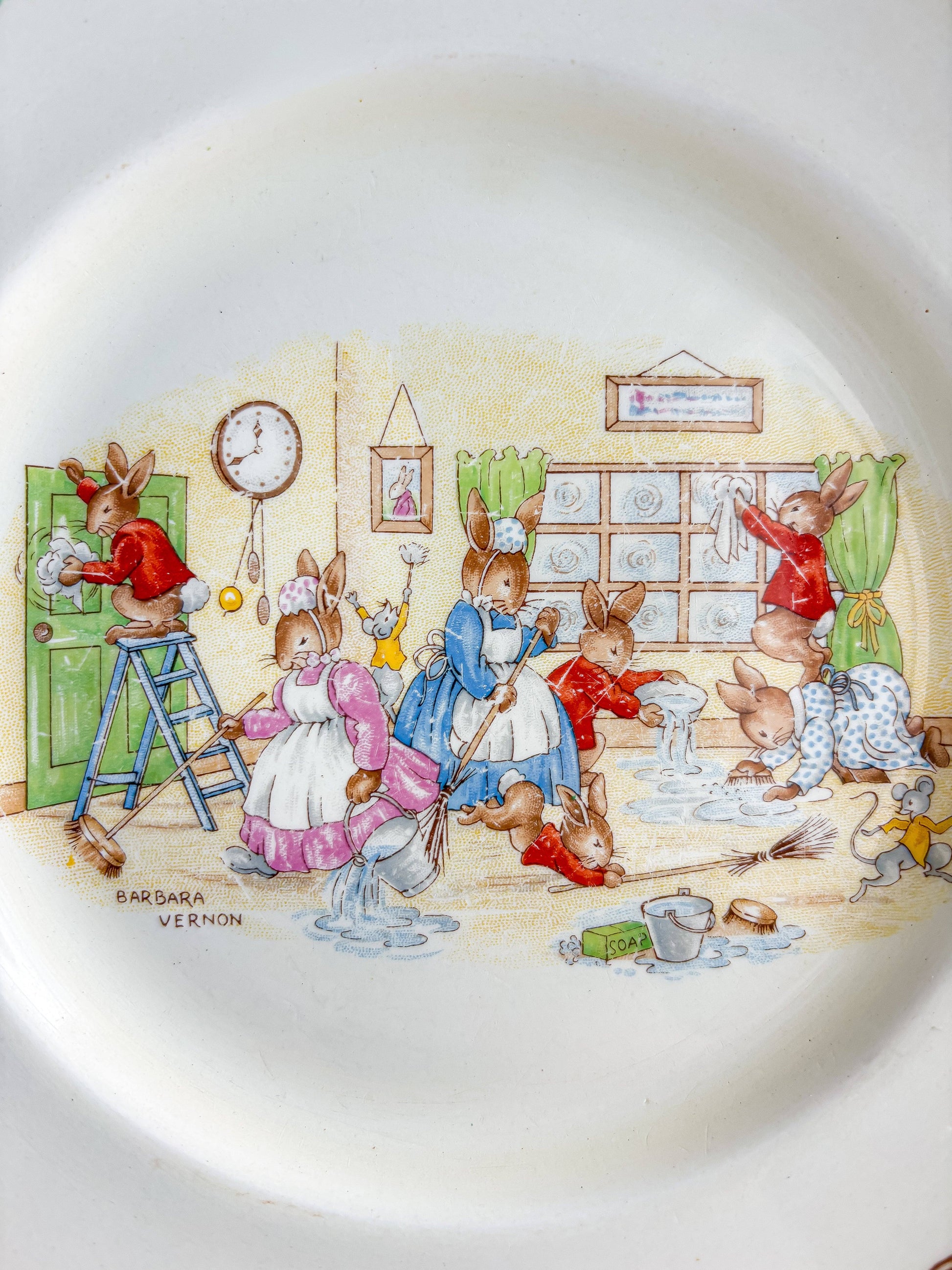 Detail of Barbara Vernon signature and Spring Cleaning illustration on vintage Bunnykins plate.
