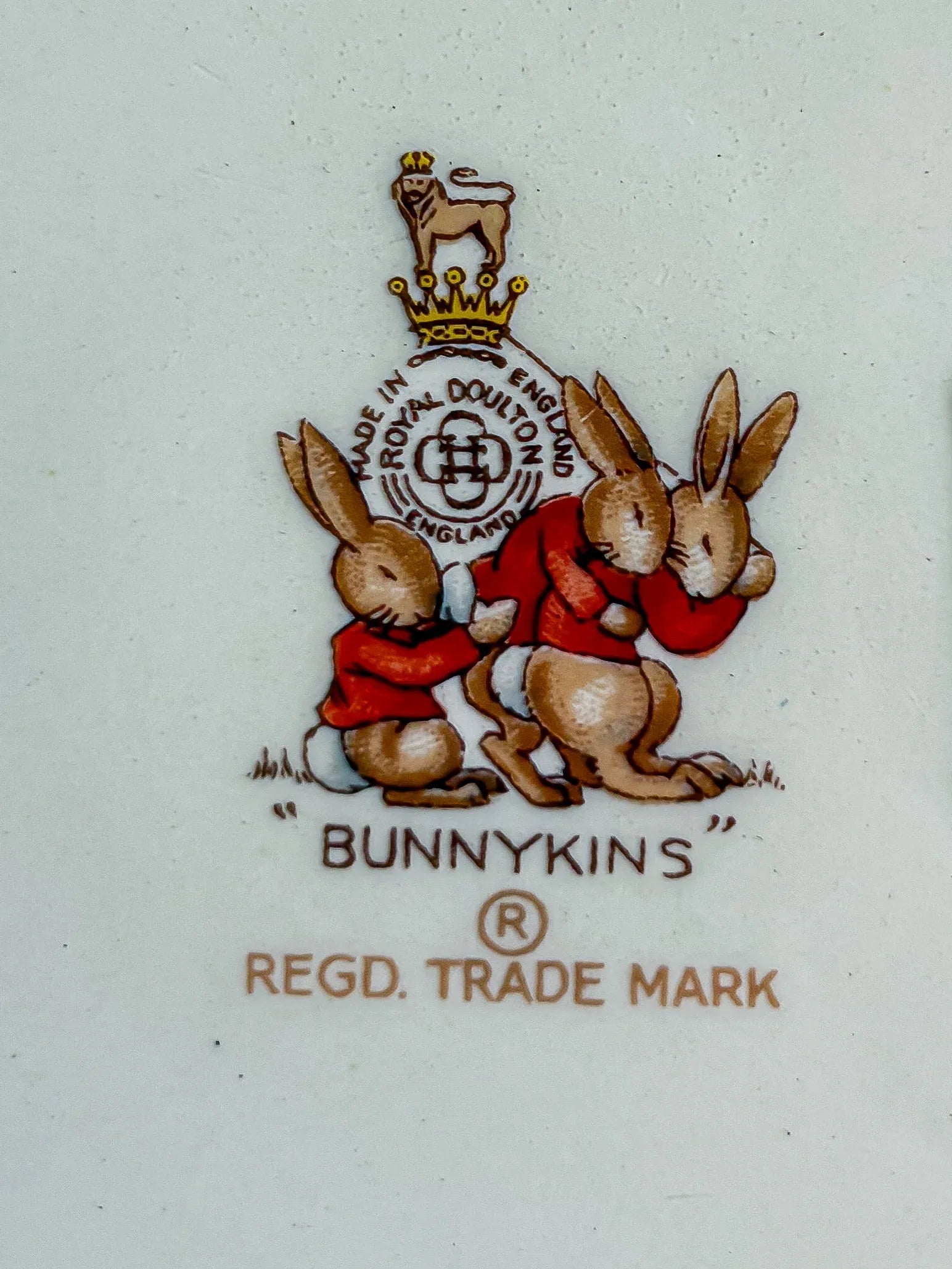 Detailed Royal Doulton Bunnykins backstamp featuring three rabbits and the Regd Trade Mark logo.