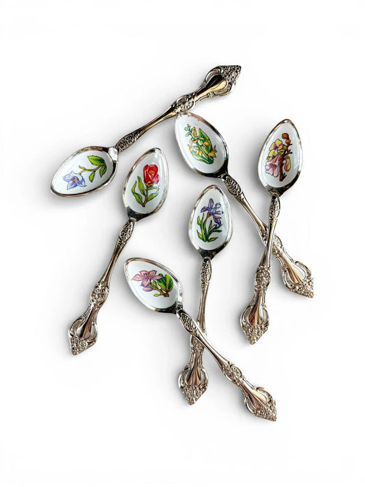A set of six vintage silver-plated teaspoons from the High Tea & Heritage collection, featuring colourful enamel botanical illustrations of Hong Kong flowers on a white background.