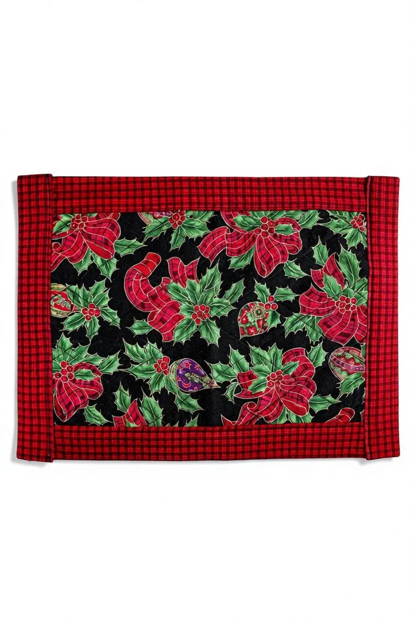 Christmas placemat with red plaid border and holly leaves, red ribbons, and ornaments on black background