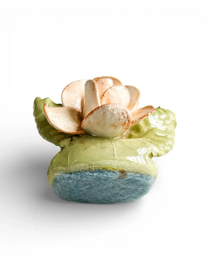 Underside view of a vintage hand-painted porcelain flower showing craftsmanship and original felt padding.