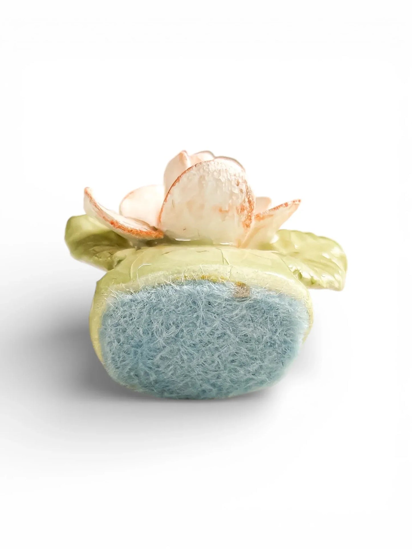 Detail of the blue felt base on a vintage porcelain floral holder to protect delicate table surfaces.