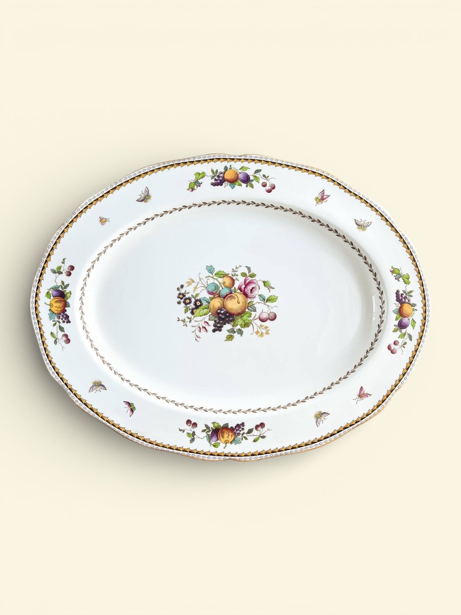 Oval porcelain serving platter with gold trim and colorful fruit and floral patterns, vintage tableware