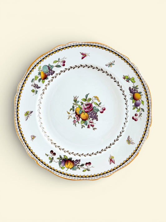 Curated vintage porcelain plate with intricate fruit and floral patterns, gold trim, and delicate insect motifs