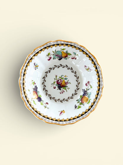 Vintage porcelain bowl with fruit and floral patterns, gold and black decorative border