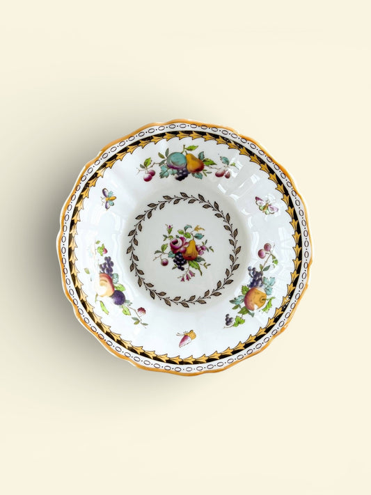 Vintage porcelain bowl with fruit and floral patterns, gold and black decorative border