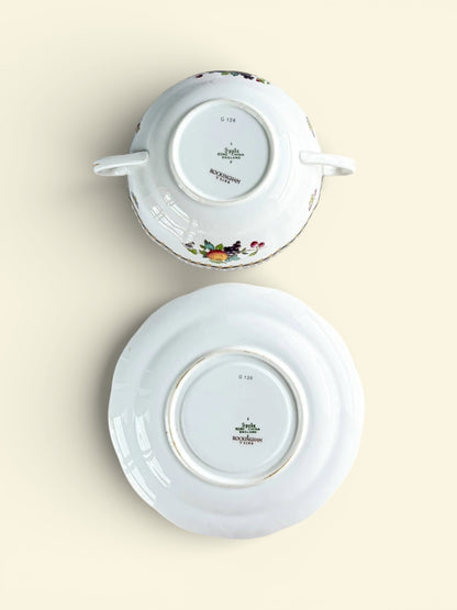 Spode Rockingham bone china cup and saucer set with floral patterns, shown upside down on beige background