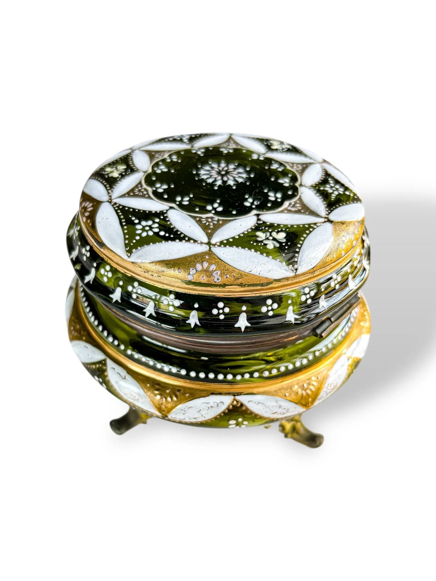 Decorative green and gold glass trinket box with white floral patterns and three small legs