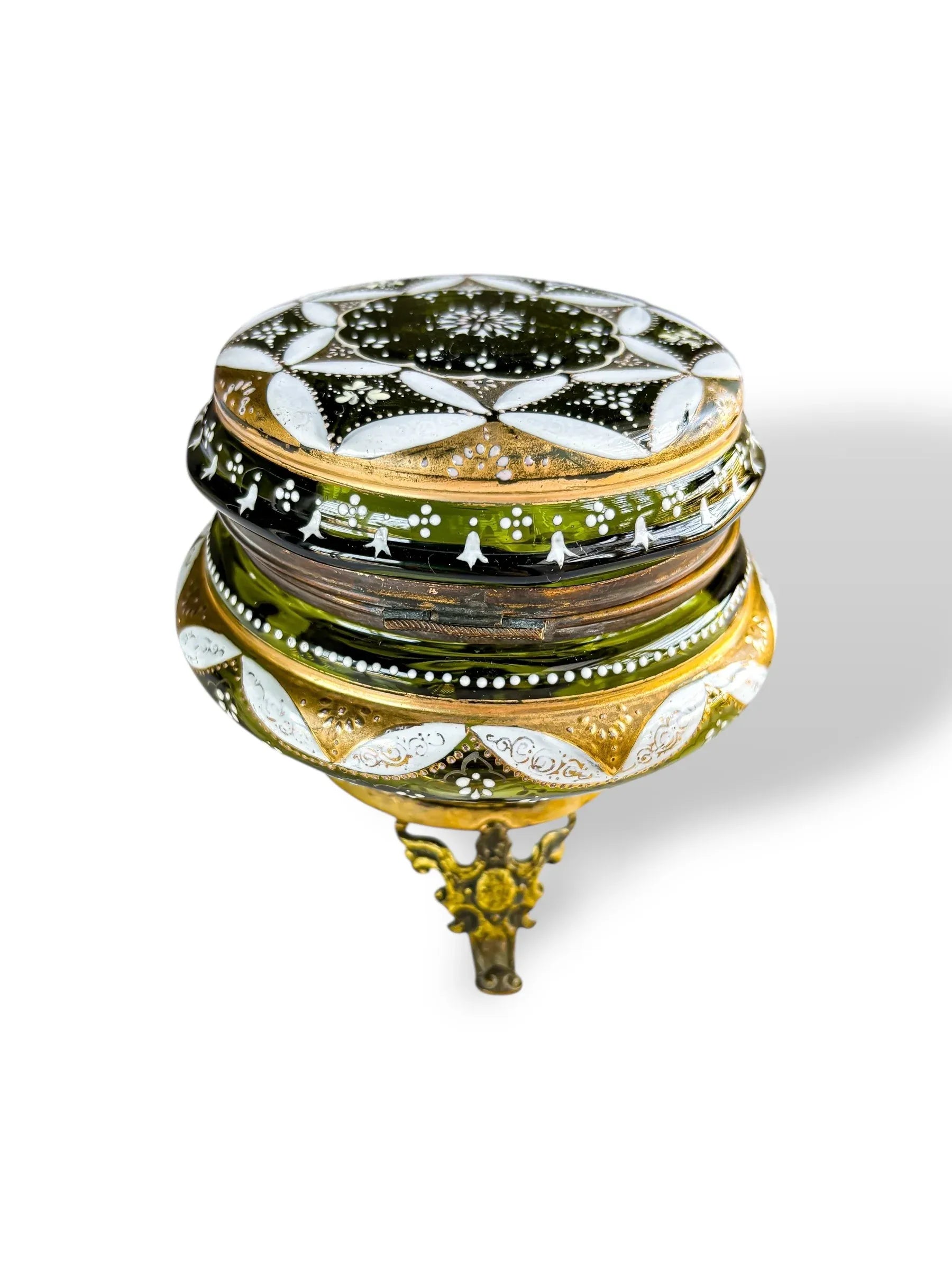 Antique green and gold glass trinket box with ornate patterns and brass tripod base