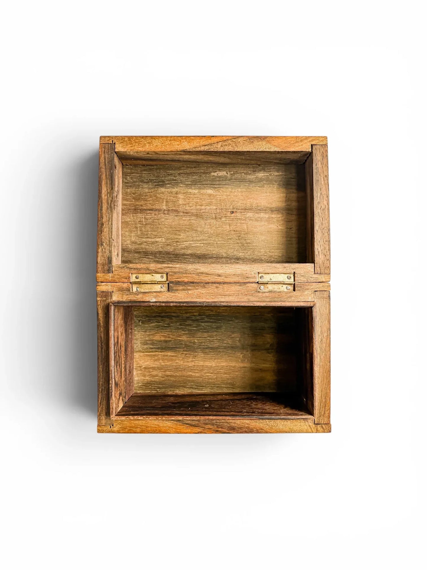 Overhead view of the vintage wooden trinket box fully open, showcasing a clean, unlined natural hardwood interior compartment and flush-mounted brass hinges on a plain white background.