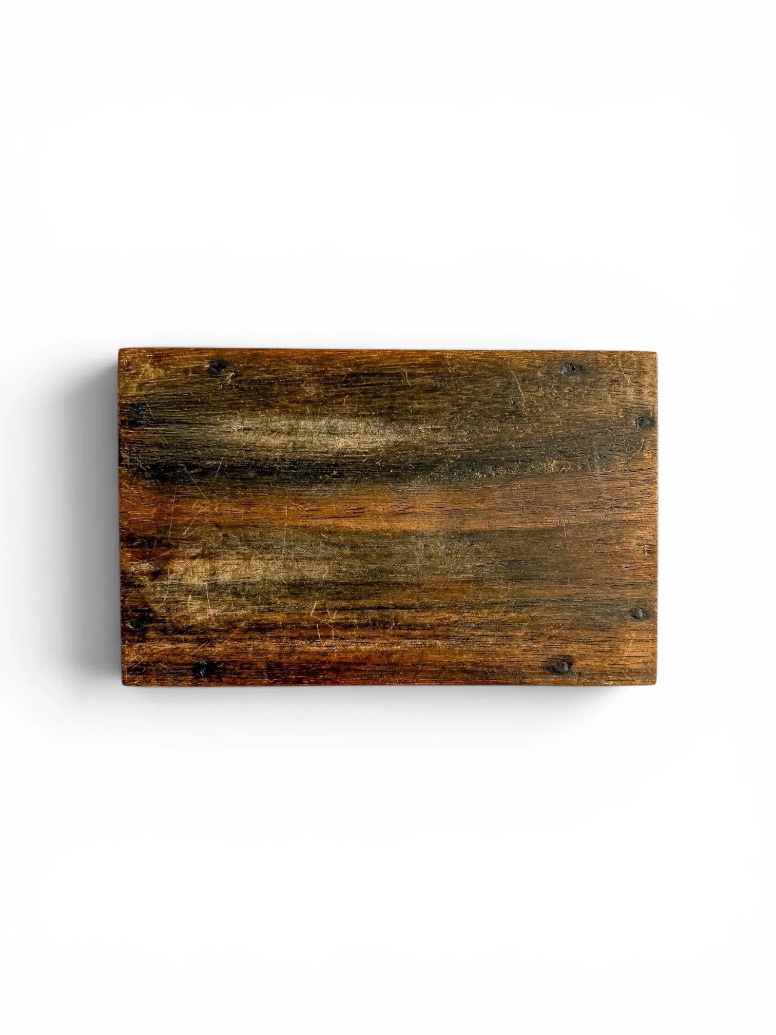 Flat lay view of the underside of the vintage hand-carved box on a solid white background, displaying the authentic patina, light surface wear, and exposed dark joinery pins of the hardwood base.