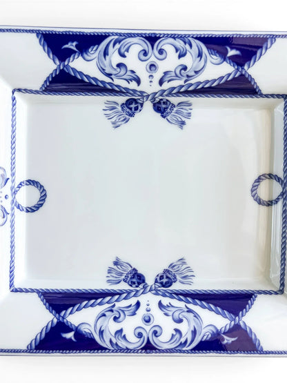 Close-up of the Vista Alegre Villa dish well, with paired cobalt tassels, rope rings and blue scrollwork on glossy white porcelain.
