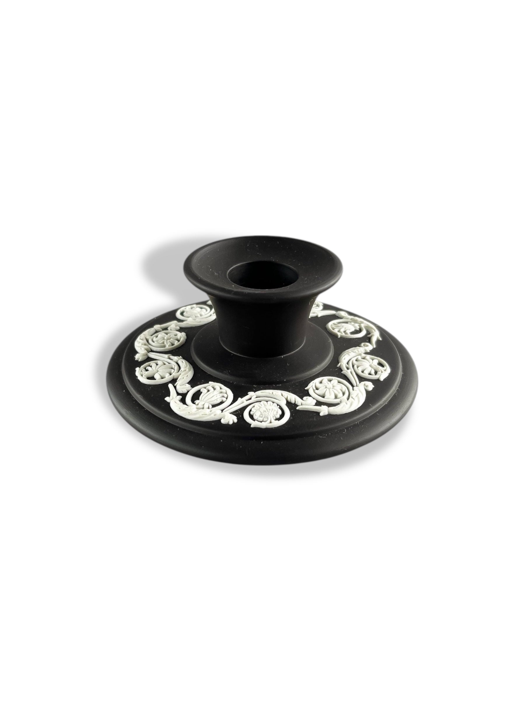 Black porcelain candle holder with intricate white floral relief design, vintage decorative tableware
