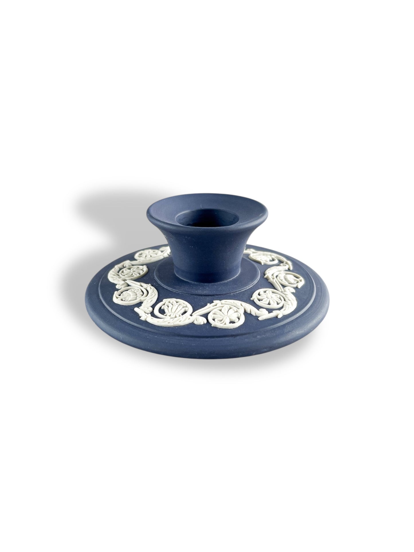 blue porcelain candle holder with white intricate floral detailing on round base