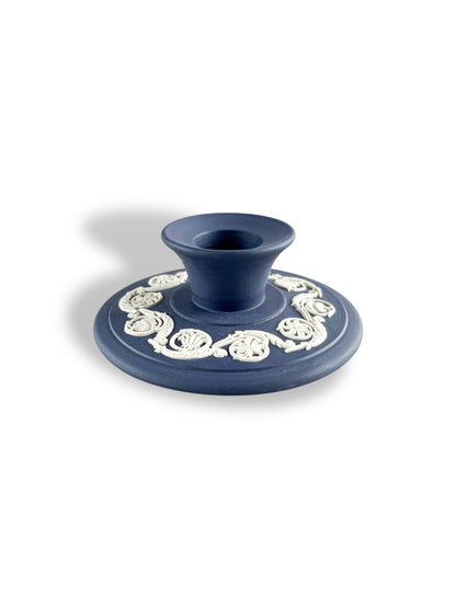 blue porcelain candle holder with white intricate floral detailing on round base