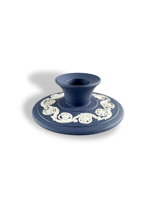 blue porcelain candle holder with white intricate floral detailing on round base